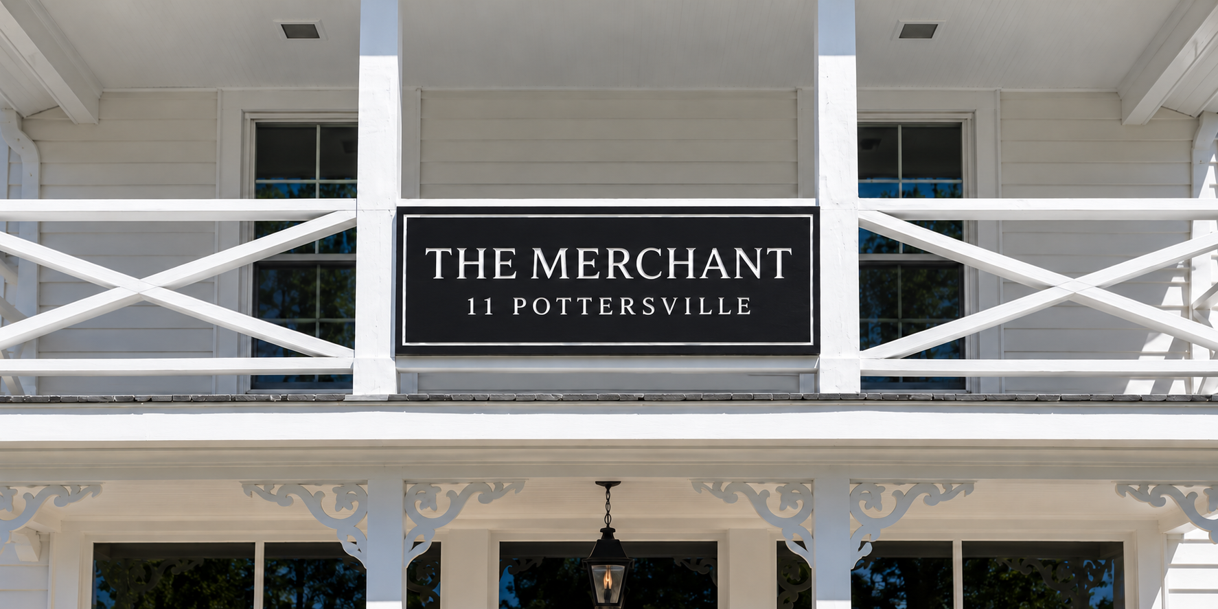 Custom black balcony railing sign for The Merchant — designed and crafted by Frenchtown Signs in Frenchtown, NJ